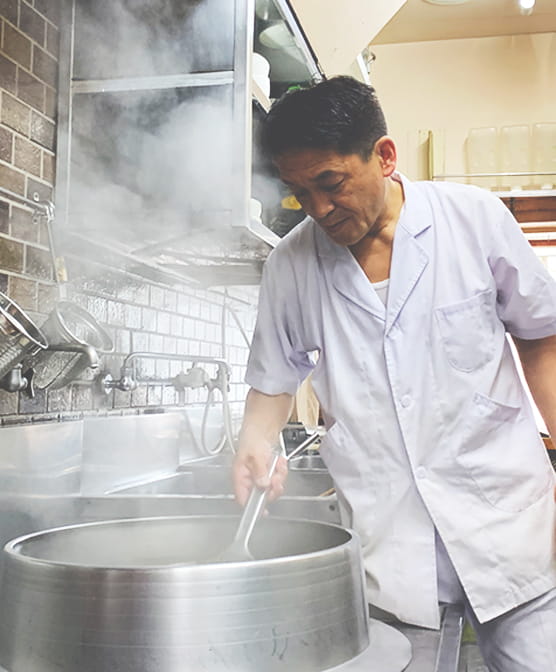 大釜でそばを茹でるめんくいの店主
